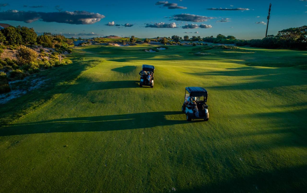 Pullman Magenta Shores Resort Entrance Zewnętrze zdjęcie Golf carts on the green